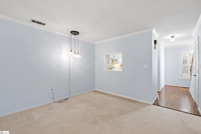 empty room with carpet, visible vents, baseboards, and ornamental molding