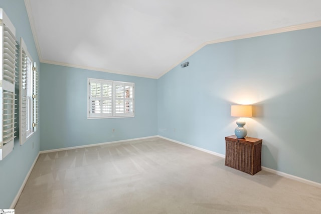 spare room with carpet floors, lofted ceiling, crown molding, and baseboards