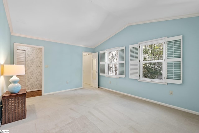 unfurnished bedroom with carpet, baseboards, vaulted ceiling, and crown molding