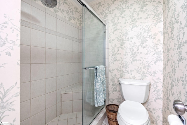 bathroom featuring a shower stall, toilet, and wallpapered walls