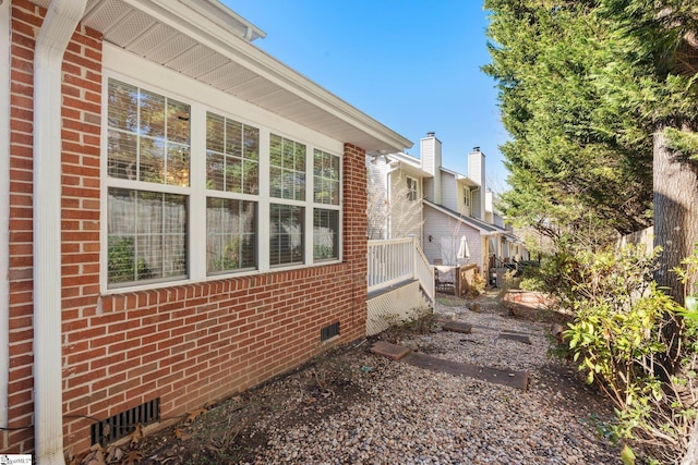 view of property exterior with crawl space and brick siding