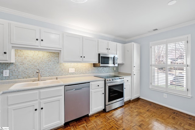 kitchen with stainless steel appliances, visible vents, decorative backsplash, white cabinets, and a sink