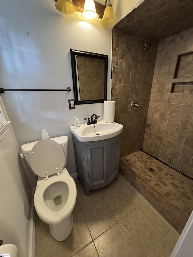 full bathroom featuring vanity, tile patterned floors, toilet, and tiled shower