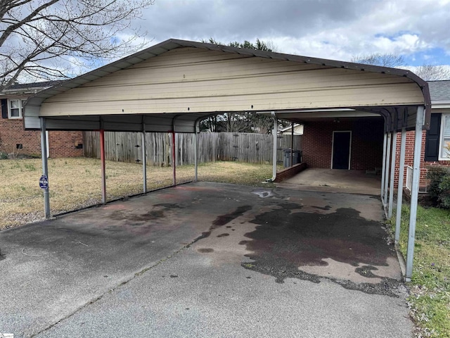 view of parking / parking lot with a detached carport and fence