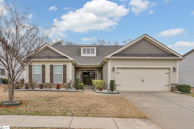 craftsman inspired home featuring a front yard, driveway, an attached garage, a shingled roof, and stone siding