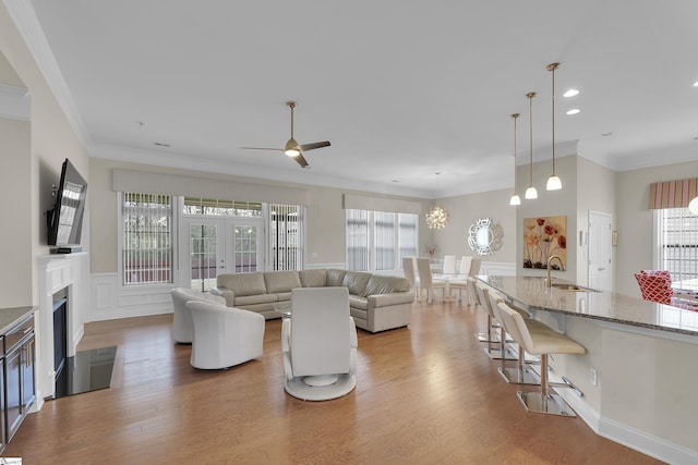 living room with ornamental molding, french doors, a fireplace, and wood finished floors