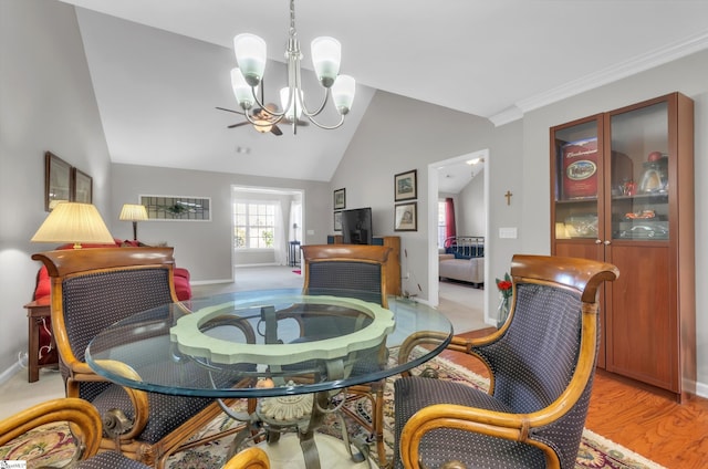 dining area featuring baseboards, lofted ceiling, a chandelier, and light wood finished floors