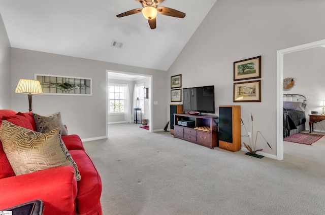 carpeted living room featuring baseboards, visible vents, high vaulted ceiling, and ceiling fan