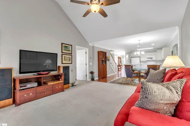 living room with high vaulted ceiling, ceiling fan with notable chandelier, carpet, baseboards, and stairs