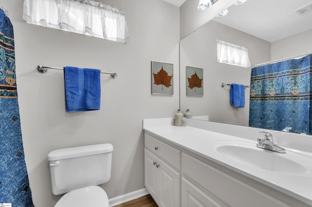 full bathroom with vanity, toilet, a shower with curtain, and visible vents