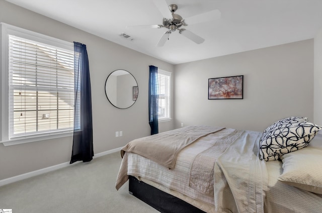 bedroom with ceiling fan, visible vents, baseboards, and light carpet