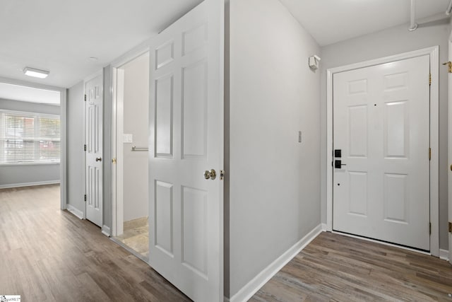 entryway with baseboards and wood finished floors