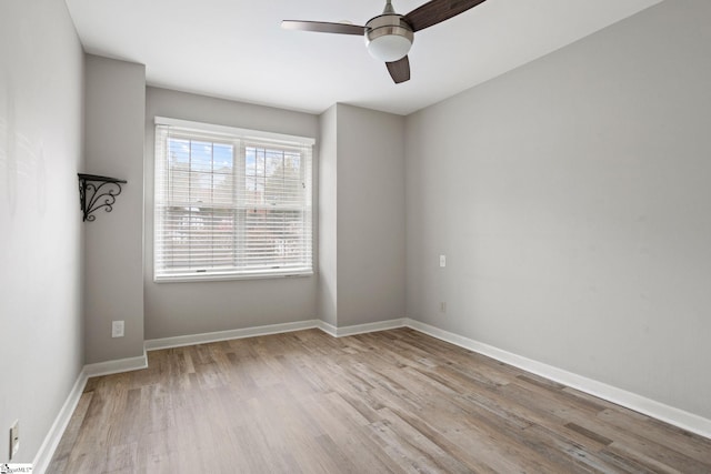 unfurnished room with a ceiling fan, wood finished floors, and baseboards