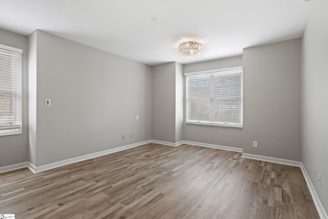 unfurnished room with wood finished floors and baseboards