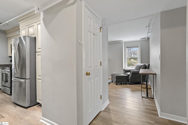 hallway with baseboards and light wood-style floors