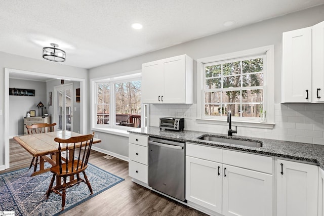 kitchen with dark wood-style floors, a sink, a healthy amount of sunlight, and stainless steel dishwasher