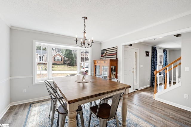 dining area featuring crown molding, a chandelier, stairs, wood finished floors, and a textured ceiling