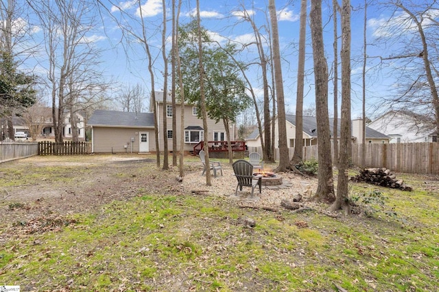 view of yard with a deck, a fire pit, and a fenced backyard