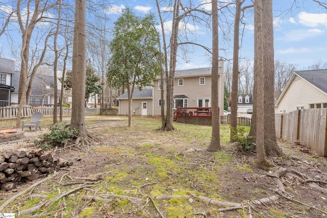 view of yard featuring an outdoor fire pit, a fenced backyard, and a wooden deck