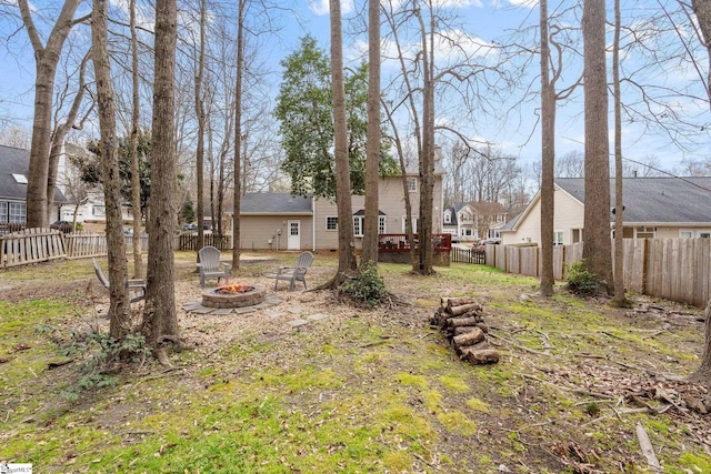 view of yard with a residential view, a fire pit, and a fenced backyard