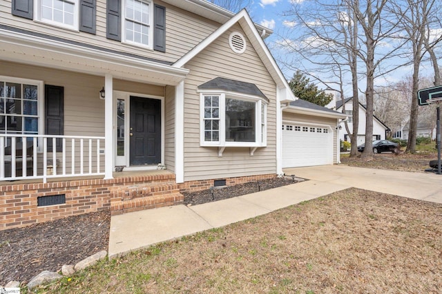 view of front of property with crawl space, driveway, a porch, and a garage