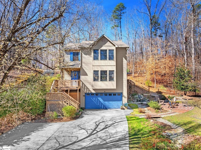 view of front of house with aphalt driveway, stairway, and a garage