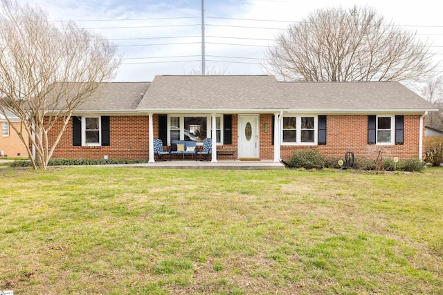 ranch-style home featuring a front yard, brick siding, and a shingled roof