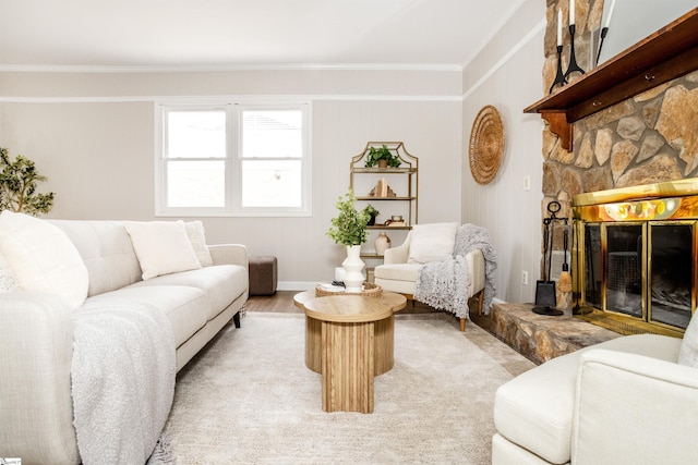 living room with light wood-style flooring, ornamental molding, and a fireplace