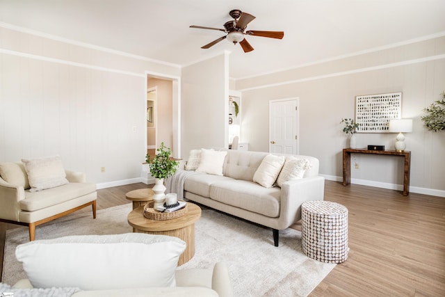 living room with baseboards, light wood-style flooring, and crown molding