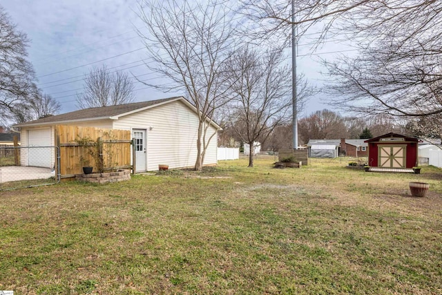 view of yard featuring a shed, an outdoor structure, and fence