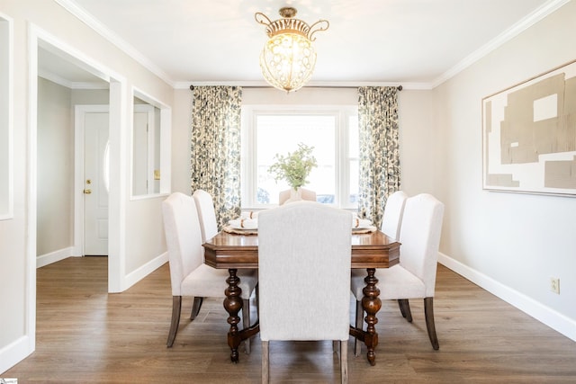 dining space with baseboards, wood finished floors, and ornamental molding