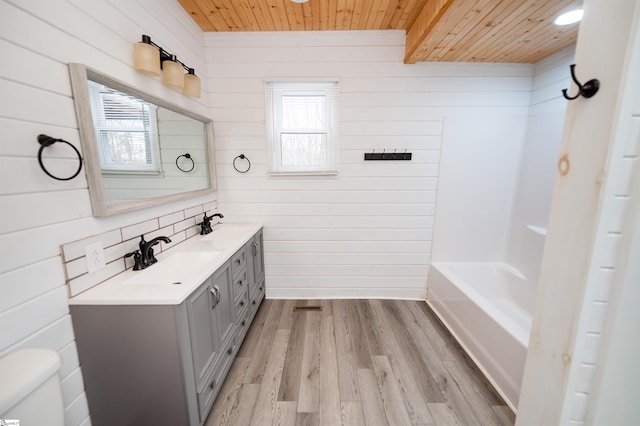 bathroom with a wealth of natural light, toilet, a sink, wood finished floors, and wood ceiling