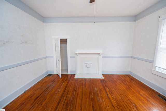 unfurnished living room featuring baseboards, visible vents, wood-type flooring, and ceiling fan