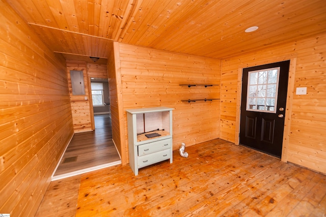 entrance foyer with a wealth of natural light, wood walls, wood ceiling, and wood-type flooring