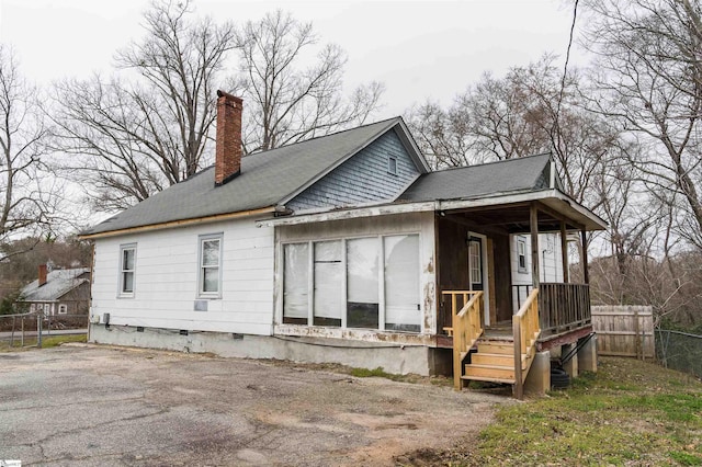 back of house with crawl space, a chimney, and fence