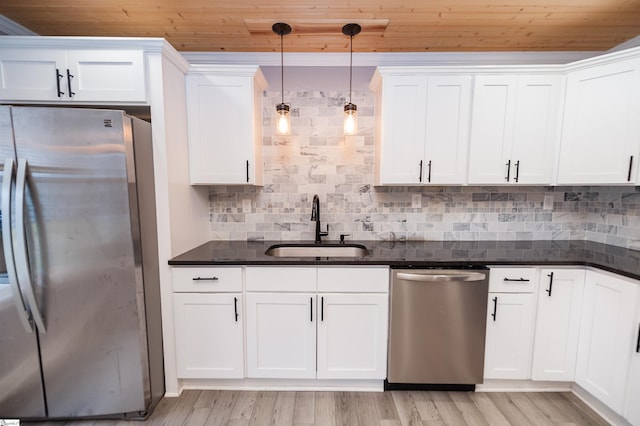 kitchen with a sink, appliances with stainless steel finishes, white cabinetry, wooden ceiling, and tasteful backsplash