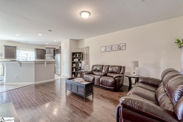 living area featuring recessed lighting, baseboards, and wood finished floors