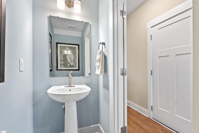 bathroom featuring wood finished floors, visible vents, and baseboards