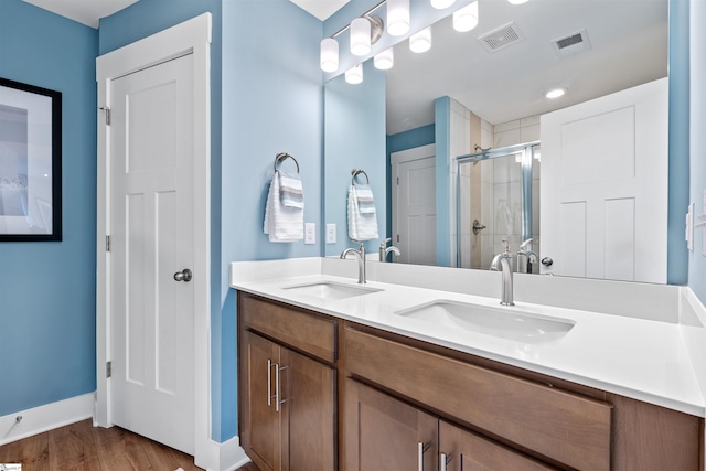 full bathroom with a sink, visible vents, a stall shower, and double vanity