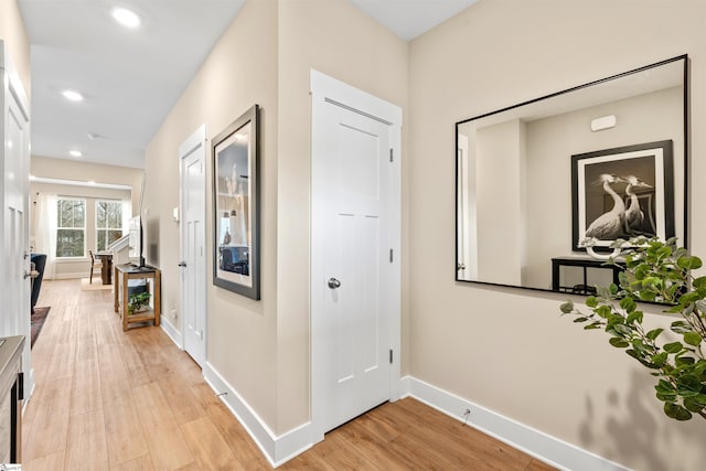 corridor featuring recessed lighting, baseboards, and light wood-style floors