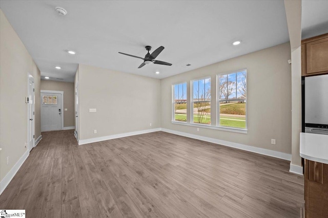 unfurnished living room with recessed lighting, a ceiling fan, baseboards, and wood finished floors