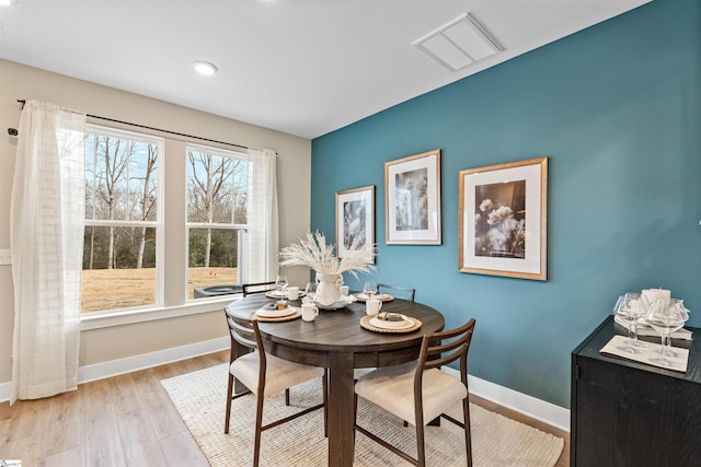 dining area featuring visible vents, baseboards, and light wood-style floors