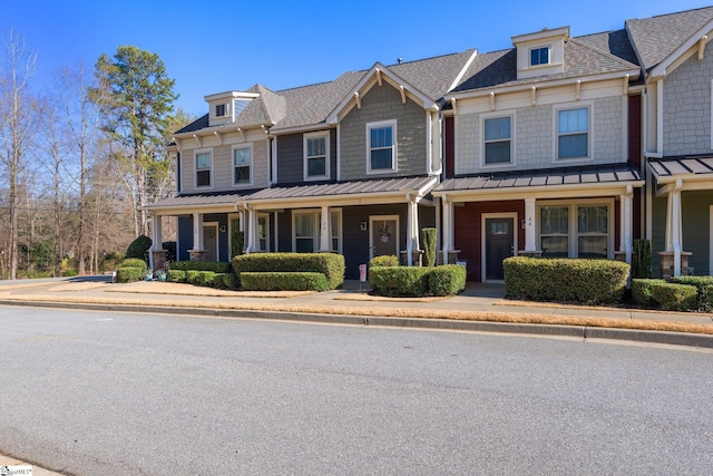 multi unit property featuring metal roof, a porch, and a standing seam roof