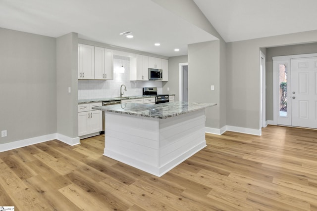 kitchen featuring light wood-style floors, stainless steel appliances, tasteful backsplash, and white cabinets