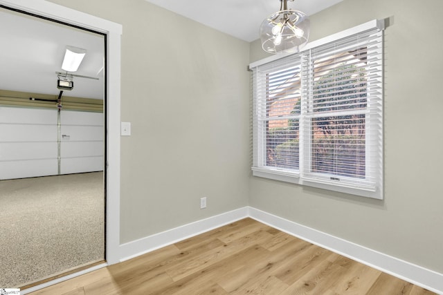 unfurnished dining area with light wood-style floors and baseboards