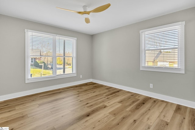 empty room with ceiling fan, baseboards, and wood finished floors