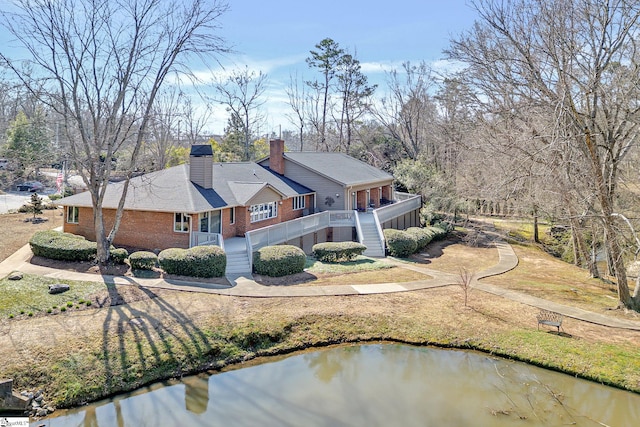 exterior space with stairway, brick siding, driveway, and a chimney