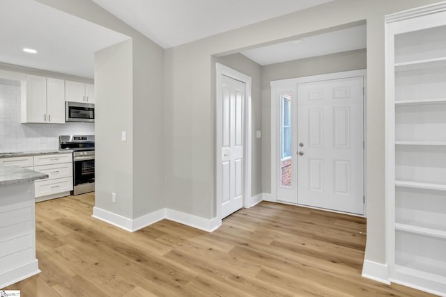 entryway with recessed lighting, baseboards, and light wood finished floors