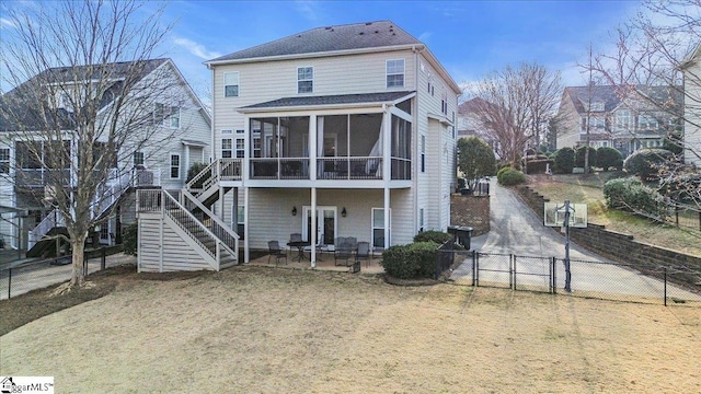 rear view of property featuring a gate, stairs, a fenced backyard, and a sunroom