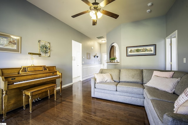 living area with visible vents, a ceiling fan, wood finished floors, wainscoting, and a decorative wall